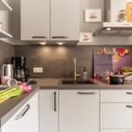 Moderne Küche mit Arbeitsplatte, Spüle und Küchenutensilien.