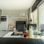 Essbereich mit Blick auf Balkon. Küche und Wohnbereich sind sichtbar.