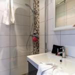 Badezimmer mit Dusche, Waschbecken und Spiegel