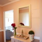 Eingangsbereich mit Spiegelschrank, Blumen und Dekorationsgegenständen.