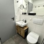 Badezimmer mit Waschbecken, Toilette und Spiegel