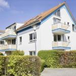 Wohnhaus mit Balkonen und begrünten Flächen