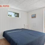 Schlafzimmer mit Bett, Fenster und Tür zur Terrasse.