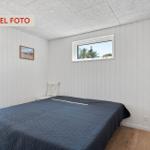 Schlafzimmer mit Bett, Fenster und Tür zur Terrasse.