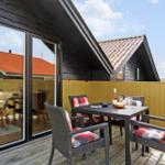 Terrasse mit Tisch und Stühlen, Blick auf benachbarte Häuser.