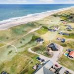 Aerial view of beachfront properties with dunes and ocean.