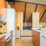 Küche mit Holzoberflächen und integriertem Schlafbereich mit Bett.