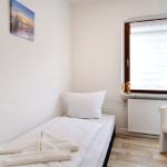 Ein Schlafzimmer mit Bett, Fenster und Sitzgelegenheit.