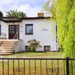 Haus Andreas mit Holztreppe und Schmiedeeisenzaun im Vorgarten.