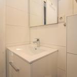 Badezimmer mit Waschbecken, Spiegel und Tür