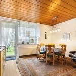 Esszimmer mit Holzdecke, Tisch mit Stühlen und Fernseher an der Wand.