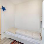 Ein Schlafzimmer mit einem Bett, einer Tür und einer blauen Stern-Dekoration an der Wand.