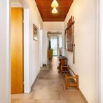 Flur mit Holzdecke, Schuhschrank und Skiaufhängern an der Wand.