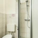 Badezimmer mit Dusche, WC und Wandbezeichnung.