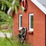 Rotes Haus mit Rettungsring und altem Rad an der Wand