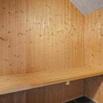 Holzsauna mit Bank und Ofen im Raum