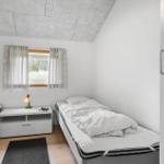 Zwei Betten, Nachttisch mit Lampe und Fenster mit Vorhängen.