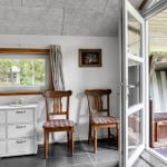 Raum mit zwei Stühlen, Schrank und Fenster. Durch Glastür Blick auf Strandkorb.