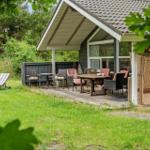 Terrasse mit Tisch, Stühlen und Liegestühlen im Garten.