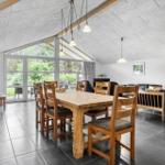 Großer Raum mit Esstisch, Sofa und Glasfront zum Garten