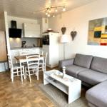 Wohnzimmer mit Sofa, Esstisch und Küche. Wandbild und Herzdekoration.