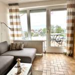 Wohnzimmer mit Sofa, Balkon und Blick aufs Meer.