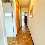 Flur mit Holzschrank, Kachelboden und Wandbild