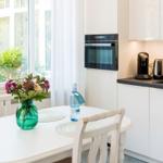 Küche mit Esstisch, Fenster und moderner Einbauküche.