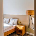 Schlafzimmer mit Bett, Nachttisch und Stehlampe.