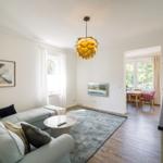 Wohn- und Essbereich mit Sofa, Tisch und Küchenzeile.