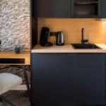 Küche mit Arbeitsfläche, Spüle, Kaffeemaschine und Kühlschrank.