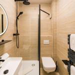 Badezimmer mit Dusche, Waschbecken und Toilette.