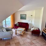 Wohnbereich mit Sofa, Sessel und TV