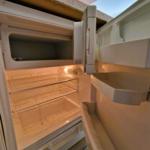 Kühlschrank mit offener Tür und leeren Regalen