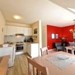 Küche mit Essbereich und Wohnzimmer mit roter Wand