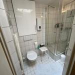 Badezimmer mit Dusche, Toilette und Waschbecken