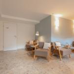 Wohnbereich mit Sitzgruppe, Wandlampen und Terrazzoboden.