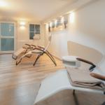 Ruhige Entspannungszone mit drei Liegestühlen und Wandbild.