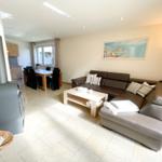 Wohn- und Essbereich mit Sofa, Kamin und Küchenbereich.