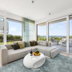 Wohnzimmer mit großem Sofa und Blick auf die Terrasse und den Hafen.