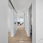 Flur mit Holzboden, weißen Wänden und Blick in Wohn- und Badezimmer.