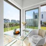 Terrasse mit Sitzgelegenheit und Blick auf Garten und Nachbarhäuser.