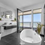 Badezimmer mit Badewanne und Blick auf den Balkon