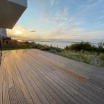 Holzterrasse mit Blick auf Wasser und Sonnenuntergang