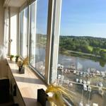 Großes Fenster mit Blick auf Hafen und Grünflächen