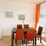 Esszimmer mit Tisch, vier Stühlen und Blick auf den Strand.