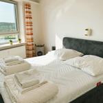 Schlafzimmer mit Bett, Fenster und Blick auf Wasser
