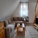 Wohnzimmer mit Sofa, TV und Holztreppe.