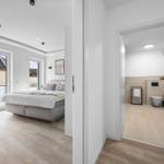 Schlafzimmer mit Blick auf Dach und Bad mit Toilette und Handtuchhalter.