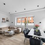 Wohn- und Essbereich mit Sofa, Esstisch und Fenster.